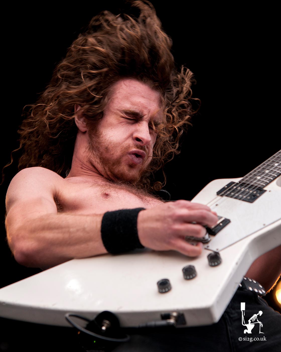 Airbourne - Joel OKeeffe, vocalist and lead guitarist for Australian hard rock band Airbourne, commands the Download Festival to rock to the tune of his white Gibson Explorer guitar.  Hidden between his fingers is the legendary Pick of Destiny, an evil yet powerful guitar plectrum used by all the greatest rock musicians.
